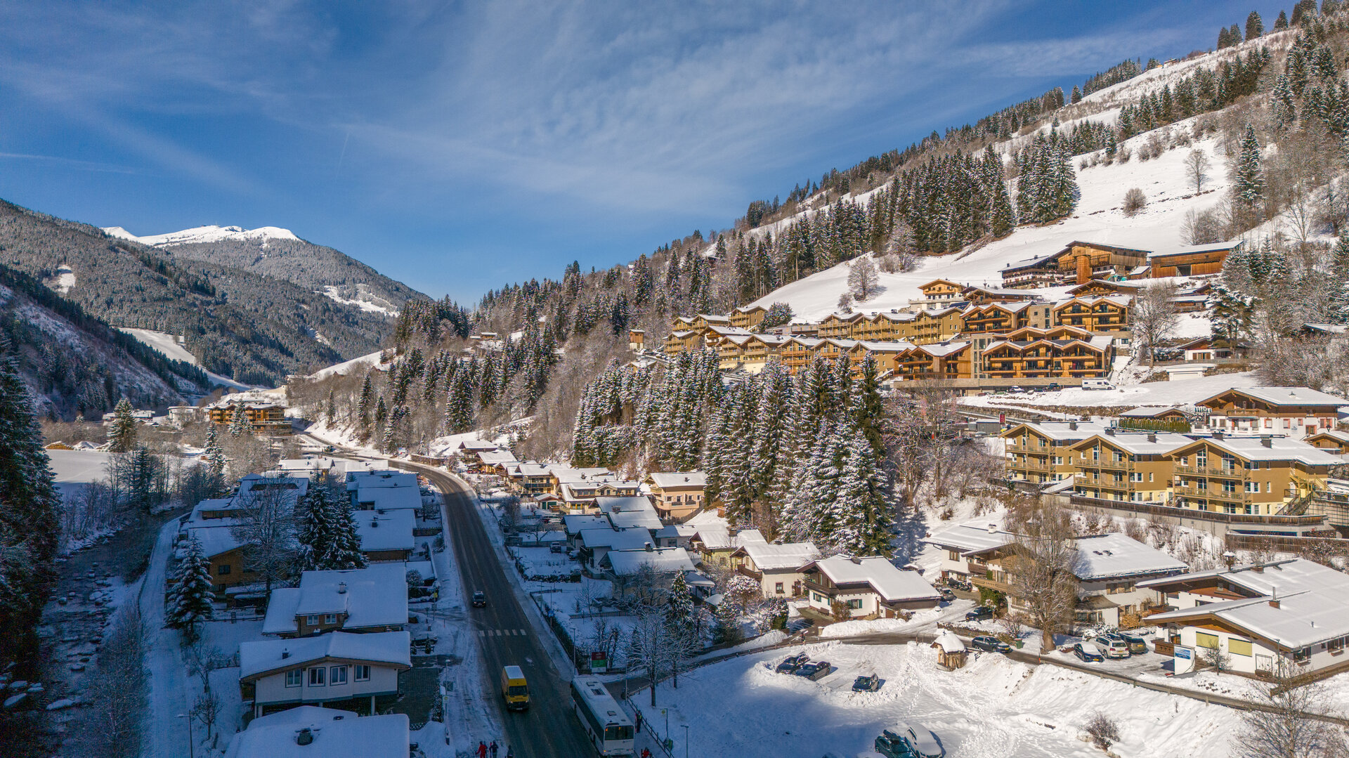 Winter view of Viehhofen with snow-covered houses, accommodation, the valley road and snowy mountain slopes. | © viehhofen.at, Der Fotoigel