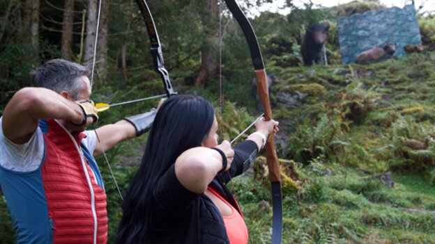 Two people practising archery on the course in Viehhofen, aiming at a 3D animal target in the forest. | © Der Fotoigel